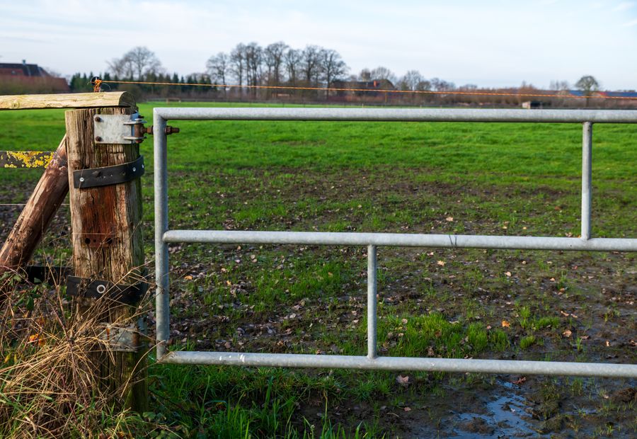 Tube farm gate hung on a braced hinge post at a ranch entrance